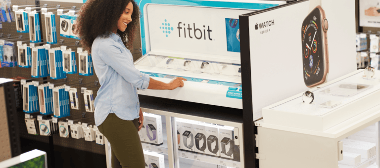 Mulher no mostruário da Fitbit em uma loja de varejo