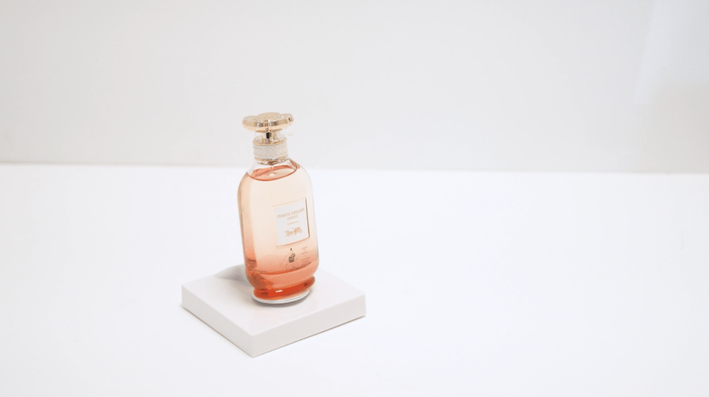 Testador de fragrâncias montado em um “ InVue Tile”, um expositor quadrado de perfil baixo, sobre uma superfície branca