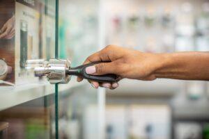 Mão usando um OneKEY para abrir uma fechadura em uma vitrine
