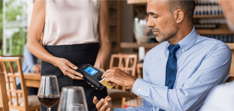 Homem usando o mPOS Handheld Case para concluir o pagamento em um restaurante.