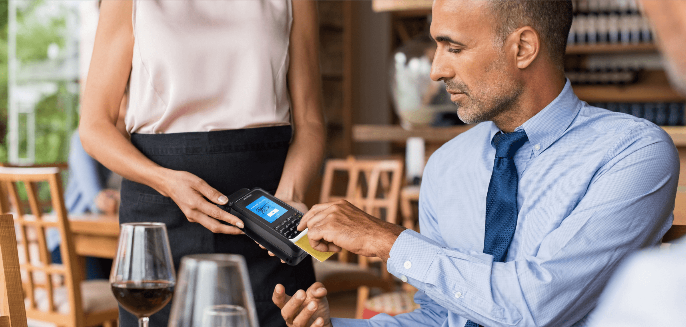 Homem usando o mPOS Handheld Case para concluir o pagamento em um restaurante.