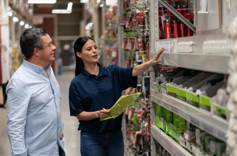 Homem fazendo compras em uma loja de materiais de construção e conversando com uma vendedora