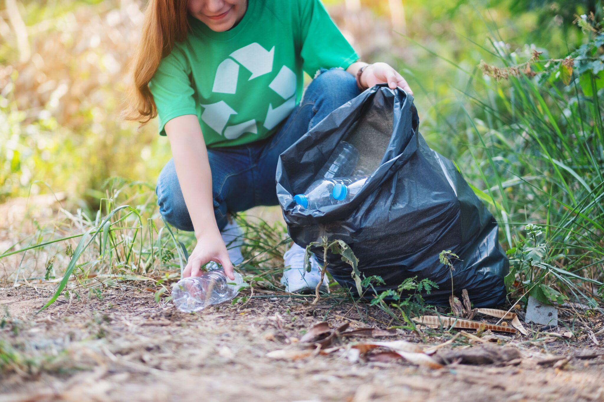 Mulher pegando a reciclagem e colocando-a no lixo